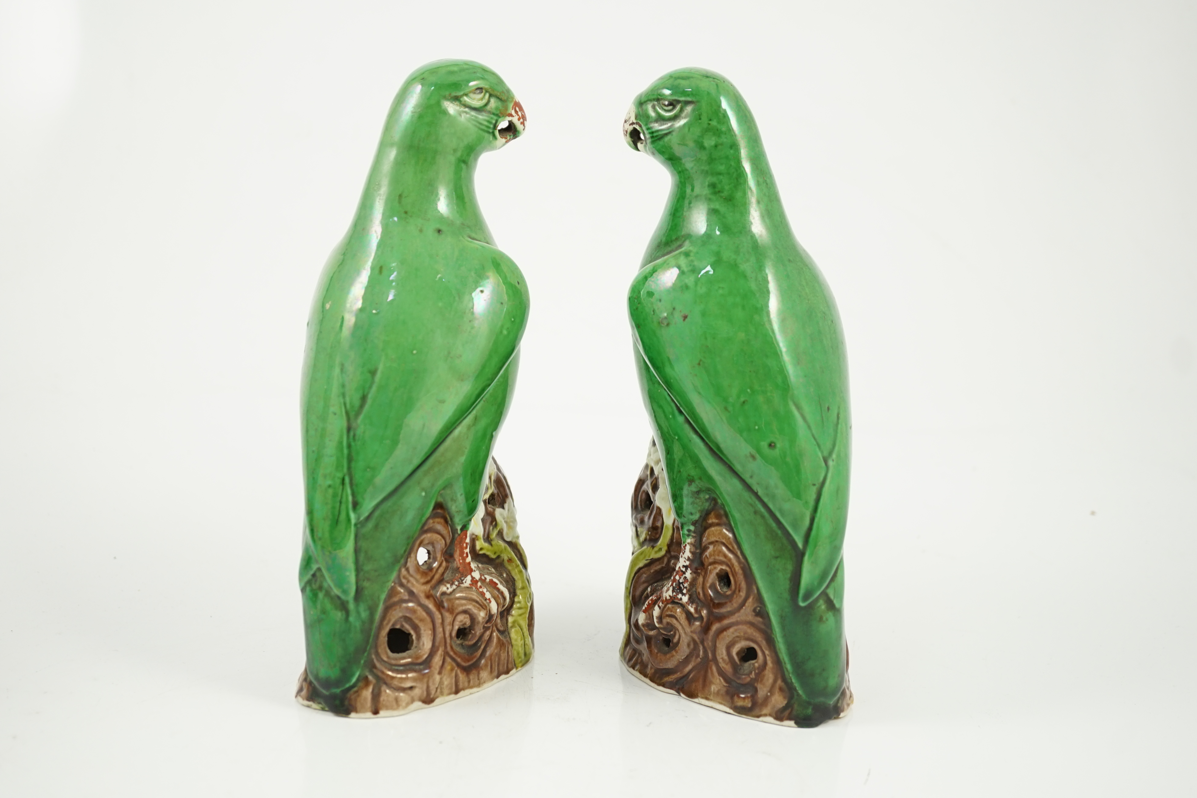 A pair of Chinese green glazed models of parrots, Kangxi period, hairline cracks to one tail feather